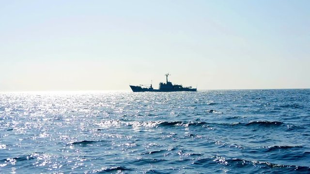 Military ship in Adriatic sea at evening shot from sailing boat. Filmed from moving sailing boat while sailing in Croatia.