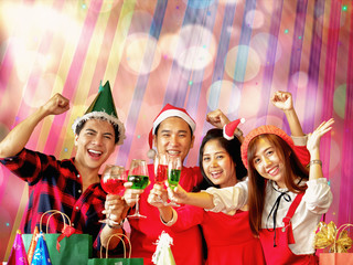 Fototapeta na wymiar Asian friends, male and female having fun celebrating in Christmas and newyear party