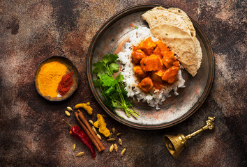 Spicy chicken tikka masala with rice, indian naan bread, spices, herbs. Indian dish.