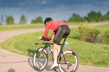 woman on sport bicycle in black helmet on road cycle scrape the curve