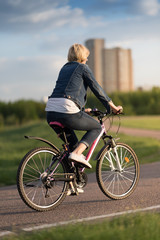 young beautiful woman riding a bicycle in a park. Active people. Outdoors