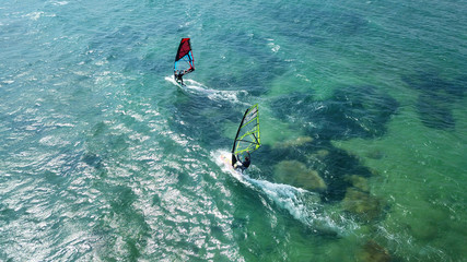 Aerial drone bird's eye view of surfer in tropical clear water beach