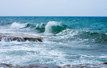 Sea wave running to the rocky shore