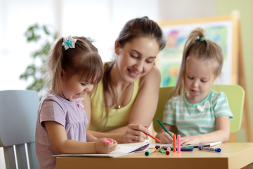 Fototapeta premium Children students with teacher drawing in art school class. Mom and kids at home. Children indulge.