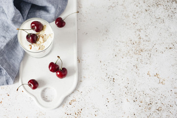 Obraz na płótnie Canvas yogurt with chia seeds, oatmeal and cherries on a light background