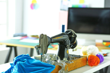 Retro sewing machine on designer clothes desktop