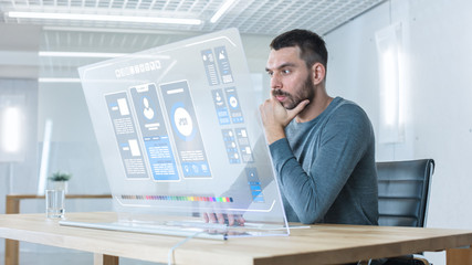 In the Futuristic Laboratory Creative Engineer Works on the Transparent Computer Display. Screen...