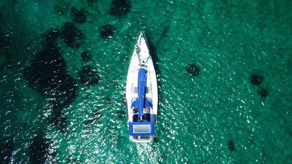 Aerial drone bird's eye view photo of sail boat docked in emerald crystal clear waters, Mykonos...