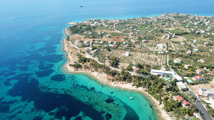 Fototapeta premium Aerial drone bird's eye view of iconic temple of Apollo on top of Kolona hill with only one pillar left standing, Aigina island, Saronic gulf, Greece