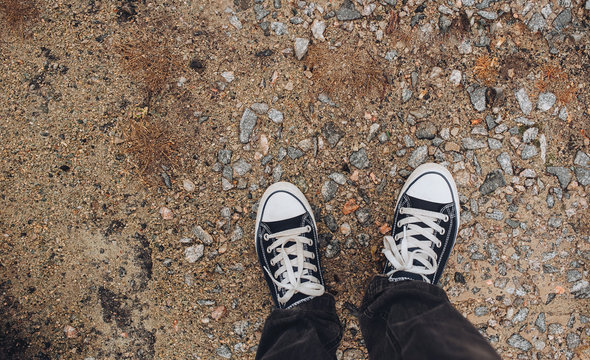 Sneakers on the gravel. Copy space. Walking on foot. Modern comfort. Shoes for Traveling.