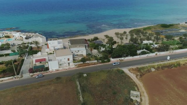 Car drive through the field near the sea in Italy Drone flight 4k