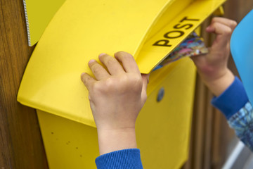 Childs Hand Puts Blank Postcard in An Italian Yellow Post Box Pi