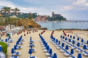 empty beach with blue chaise longues and calm sea water with ol