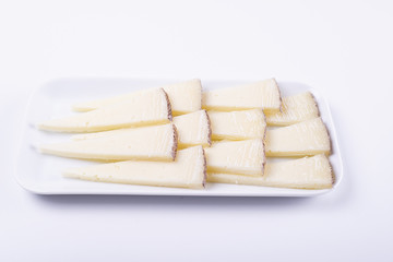 Cheese cut on plate next to fork on white background. Isolated. Food