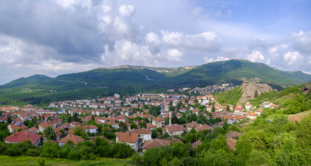Fototapeta na wymiar Panorama of a city in the mountains on a background of a cloudy sky 1
