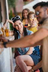 selective focus of happy young people drinking beer at beach bar