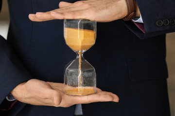 Man holding hourglass, closeup. Time management concept