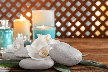 Fototapeta na wymiar Spa stones with beautiful flowers on wooden table
