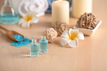 Fototapeta na wymiar Bottles of essential oil for spa procedures on table
