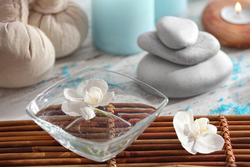 Bowl with floating flower in water on table