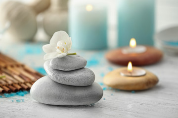 Fototapeta na wymiar Stack of spa stones with beautiful flower on table