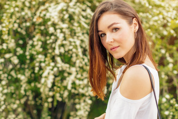 Fototapeta premium Portrait of a young attractive woman in a street on a sunny day