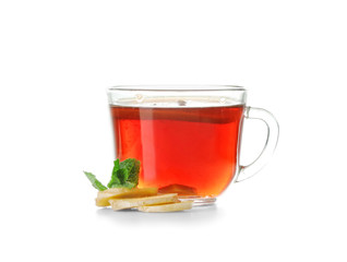 Delicious tea with lemon, ginger and mint in glass cup on white background