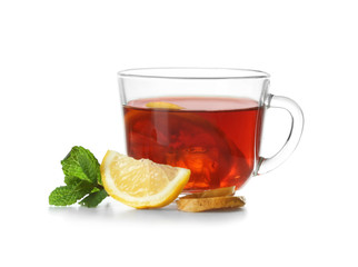 Delicious tea with lemon, ginger and mint in glass cup on white background