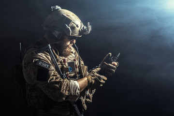 Special forces soldier with rifle on dark background