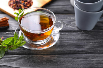 Glass cup with aromatic tea on table