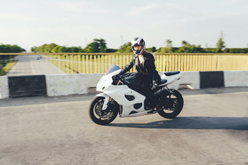 Woman biker driving a motorbike on a road