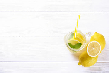 One mason jar glass of homemade refreshing lemonade with slices of organic ripe lemon, whole and...