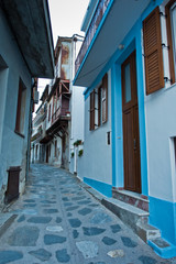 Narrow, winding and steep cobblestone streets at sunset, city of Skopelos, Skopelos island in Greece 
