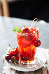 Red compote juice with fresh cherry and strawberry