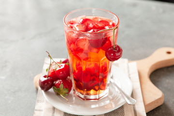 Red compote juice with fresh cherry and strawberry
