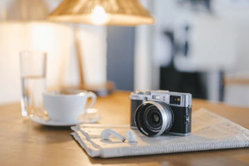 Earphone, newspaper and camera on table in a cafe