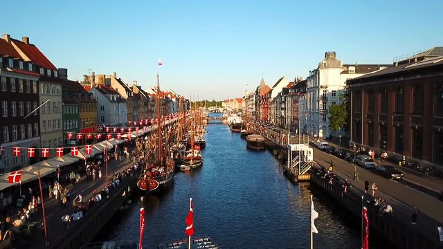 Camera takes off over the old canal of Copenhagen, Denmark. bridge in Nyhavn New Harbour canal and entertainment district. Video footage. Aerial view from the top.