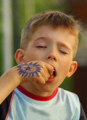Closeup portrait of a boy eating crisps with eyes closed