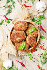 Homemade pork-beef cutlets or meatballs in a bowl, rustic style, vintage wooden background, top view