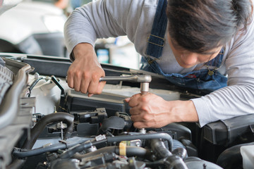 Hands of car mechanic in auto repair service.