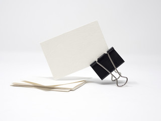 White blank business card being held by a black binder clip, isolated, mock up