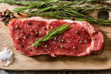 Raw beef steak with spicy ready to be cooked on wooden table. Top view