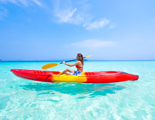 Fototapeta na wymiar Asian woman on the kayak boat in Andaman blue sea and blue sky background location in Phuket island Thailand
