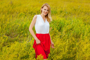 Naklejka na ściany i meble girl posing in a field with flowers