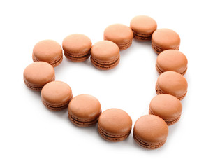 Heart made of chocolate macarons on white background