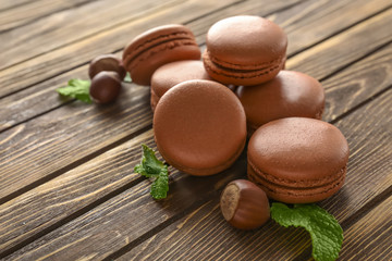Tasty chocolate macarons on wooden background