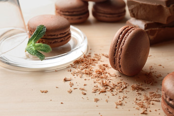Delicious chocolate macarons on table