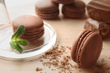 Delicious chocolate macarons on table