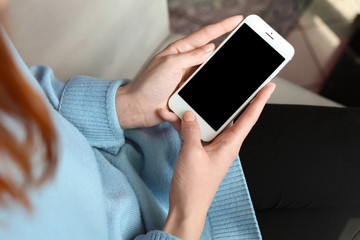 Woman using mobile phone indoors