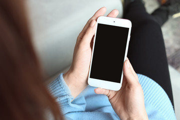 Woman using mobile phone indoors